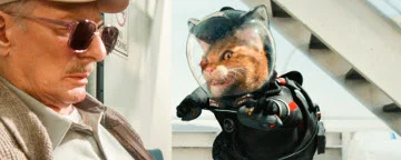 An Old Man Looking At A Cat in A Space Outfit